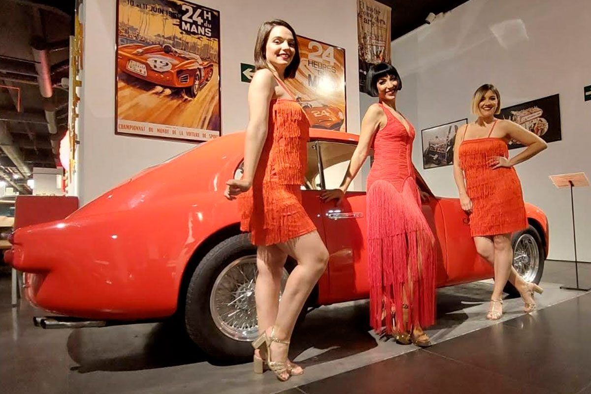 The-Vintage-Experience-Actuacion-11 Bailarinas y cantantes de genero musical charleston posando junto a coche clásico en museo temático en Museo del Automóvil Málaga