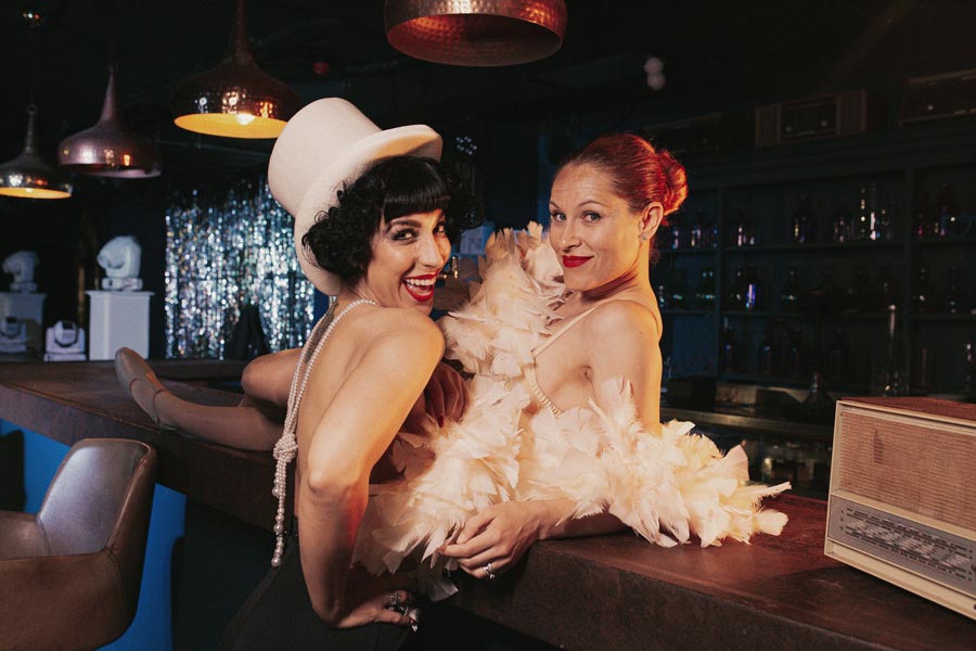 Timeless Duet Dúo vocal femenino posando en bar vintage con estética swing elegante
