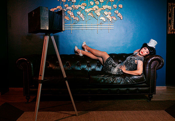 Virginia-The-Vintage-Experience-600px Bailarina estilo fiesta gatsby relajada en sofá vintage durante sesión artística del espectáculo